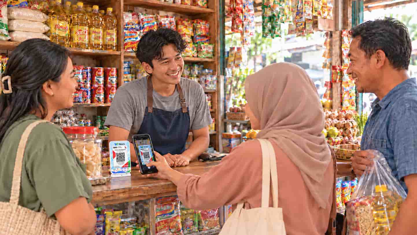 Customer scanning a Warqris payment code at a neighbourhood shop